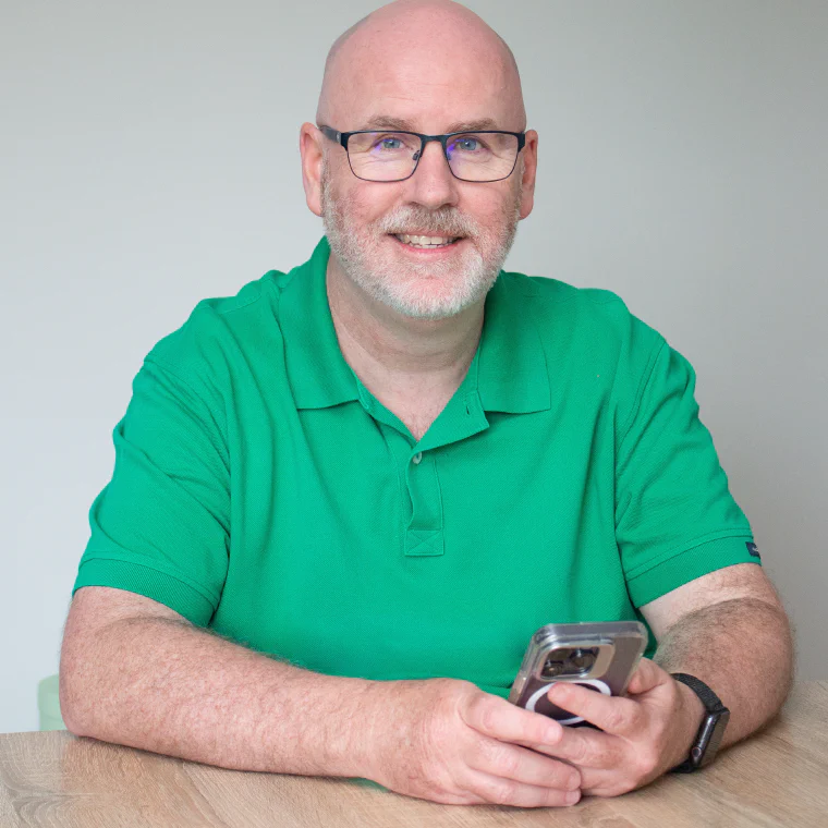 Jay, who builds jaydo, sitting at a desk holding an iPhone.